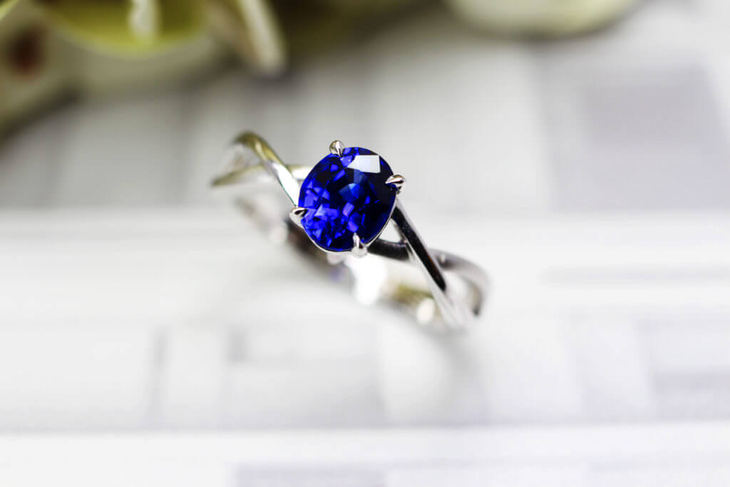 Customised  Proposal Ring with vivid blue sapphire coloured gemstone. Designed with twisted band from sketch and handcrafted to final piece | Local Singapore custom made jeweller in wedding jewellery and proposal ring for engagement with coloured gemstone and diamond. 