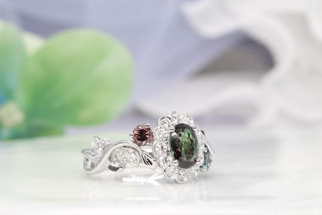 Alexandrite gem appears green under daylight and reddish-purple under incandescent light, colour change phenomenon. Customised flora ring with halo diamonds set around the alexandrite, resemble a flower design. Customised Jewellery with colour change alexandrite jewellery in Singapore