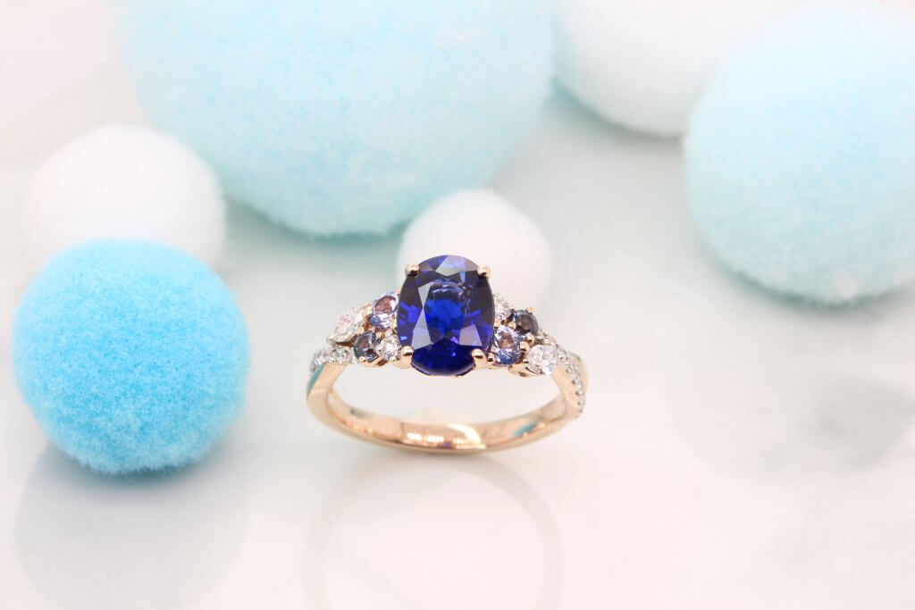 Featuring a vivid blue sapphire gem with cluster blue spinel and marquise shaped diamond design. Exceptional Sapphire engagement ring customised unique design.